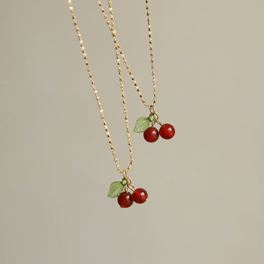Lilyah Jewelry Necklace. Gold plated necklace with cherry pendants on a neutral background