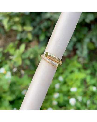 Lilyah Jewelry Gold Plated Zircon Diamond Ring. adjustable promise ring. accents of gold and diamonds. ring with diamonds on a white stick against a blurred green background