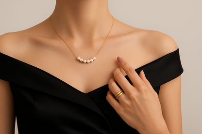 Lilyah Jewelry Gold Plated Necklace. Gift Ideas for her. A person wearing a black off-shoulder top showcasing a 18k gold plated necklace with white pearls.