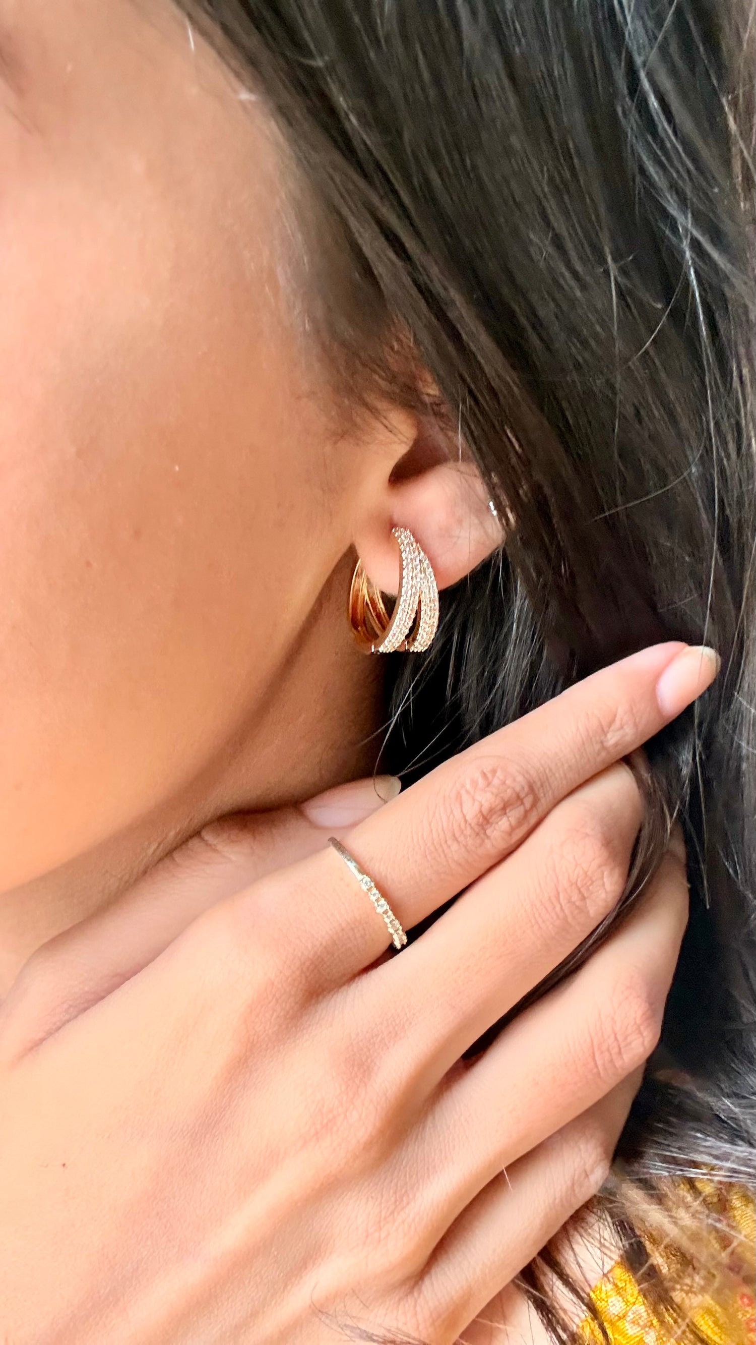 Lilyah Jewelry Gold Plated Diamond Earrings. Close-up of an ear wearing a gold earring with a hand touching the earlobe.