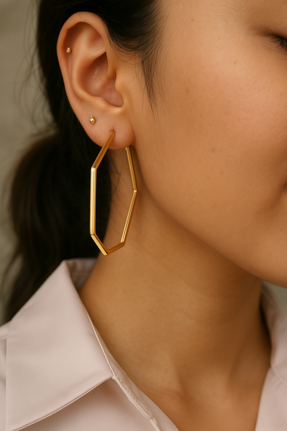 A close-up image of a woman's ear wearing a gold-plated hexagon hoop earring. Lilyah Jewelry Gold Plated Earring. Gift Ideas for her.