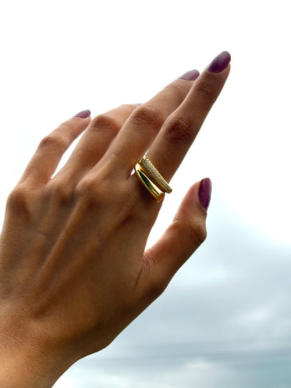 Lilyah Jewelry Gold Plated Zircon Diamond Ring. adjustable promise ring. accents of gold and diamonds. Hand wearing a gold ring with a blurred sky background