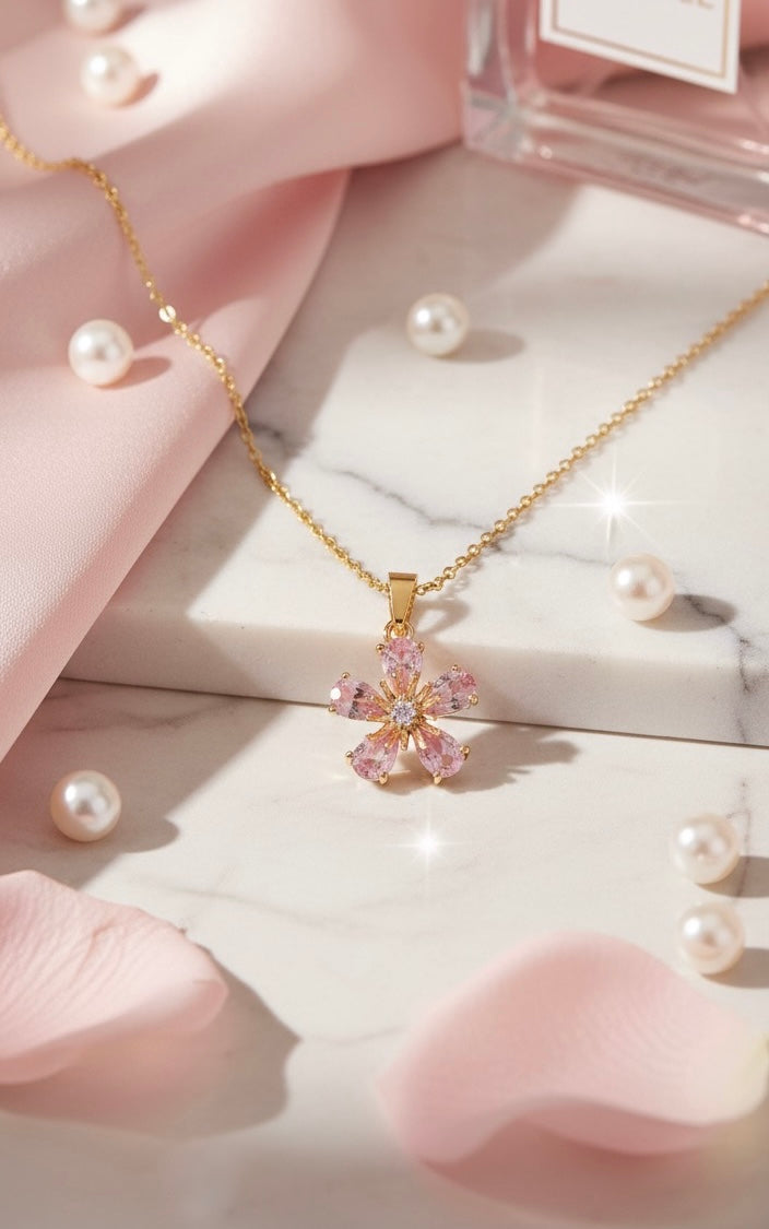 Gold plated necklace with a pink flower pendant on a marble surface with pearls and a pink box. Lilyah Jewelry Gold Plated Zircon Diamond Necklace.