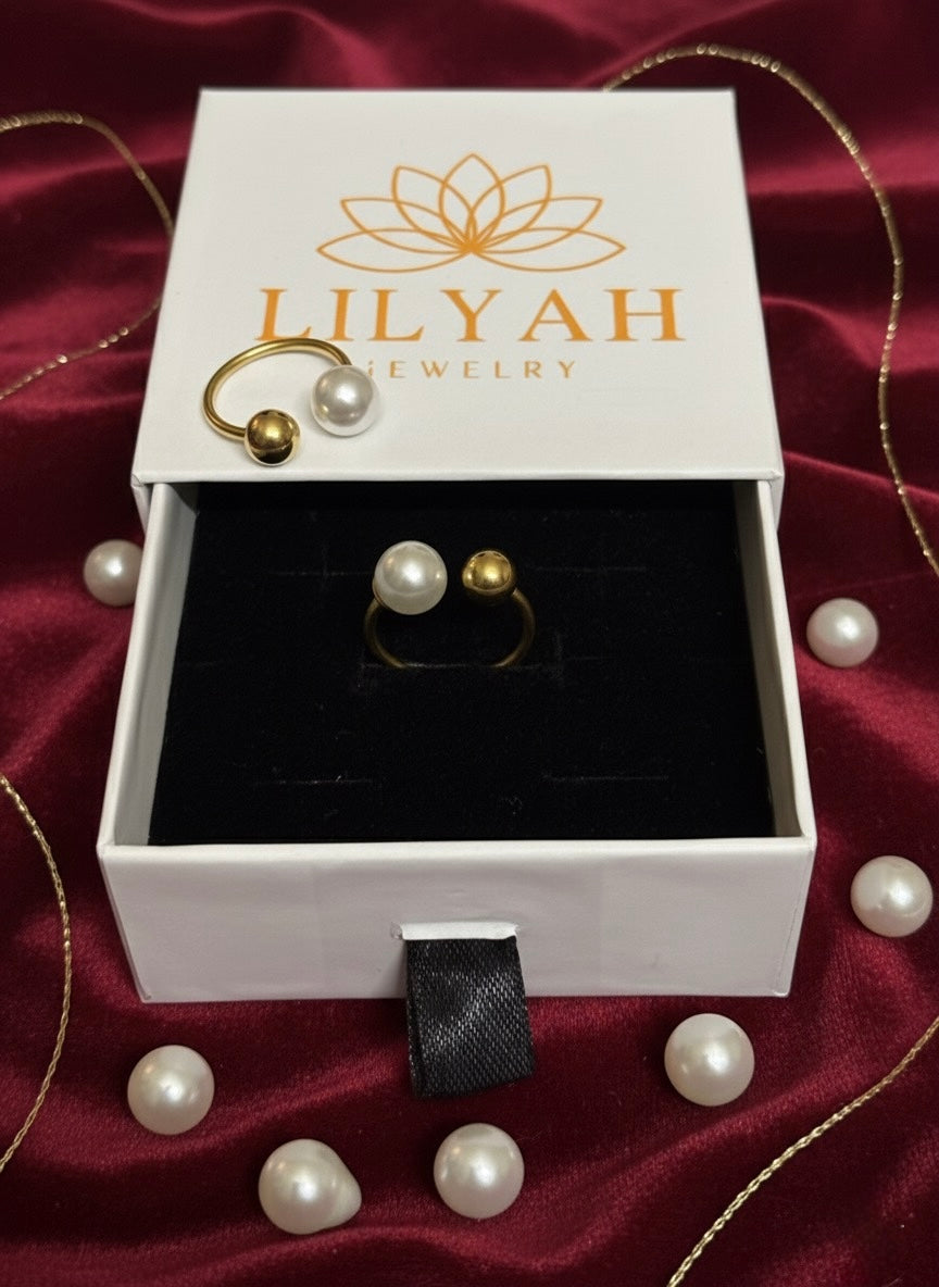 Lilyah jewelry box with gold rings and pearls on a red satin background
