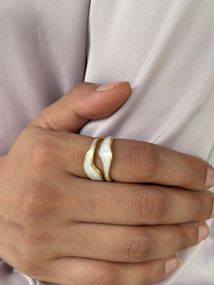 An 18k gold plated midnight pop open ring with a white inlay, displayed on a finger. Lilyah Jewelry Gold Plated Ring . Stunning, minimalistic, adjustable, elegant and statement ring. Gift idea for her.