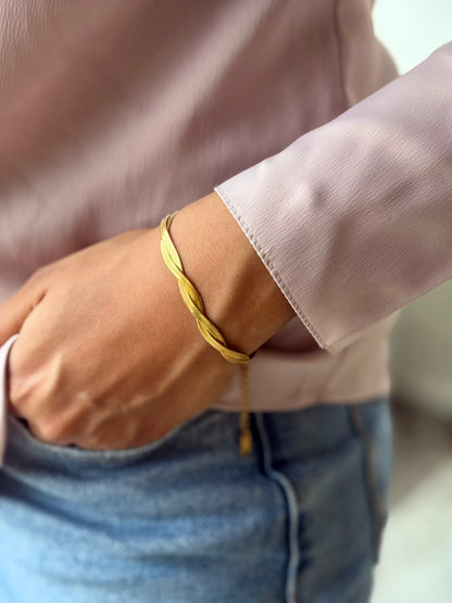 A close-up image of a person's wrist wearing a gold-plated twisted snake chain bracelet. Lilyah Jewelry Gold Plated Delicate Bracelet . Stunning, minimalistic and elegant. Gift for her