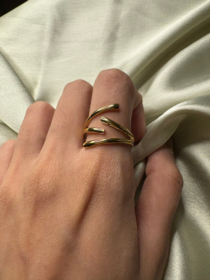 Hand wearing a gold ring on a beige fabric background. Lilyah Jewelry Gold Plated Ring . Stunning, minimalistic, adjustable, elegant and statement ring. Gift idea for her.