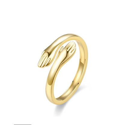 A gold-plated titanium steel ring with a design resembling two hands embracing, symbolizing love and protection. the hug ring. Lilyah Jewelry Gold Plated Ring . Stunning, minimalistic, adjustable, elegant and statement ring. Gift idea for her.