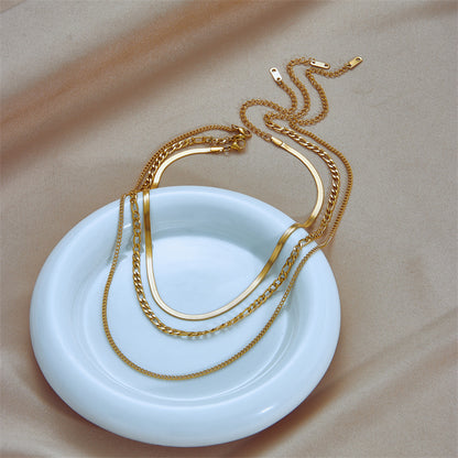 A gold-plated layered link necklace displayed on a white dish against a neutral background. Lilyah Jewelry Gold Plated Necklace. Gift Ideas for her.