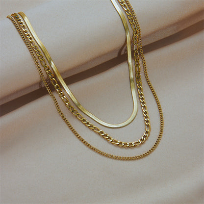 A set of layered gold-plated necklaces with a bold link design, displayed on a cylindrical object. Lilyah Jewelry Gold Plated Necklace. Gift Ideas for her.