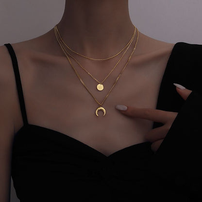 A model wearing a triple layered gold-plated necklace with Luna-shaped pendants. Lilyah Jewelry Gold Plated Necklace. Gift Ideas for her.