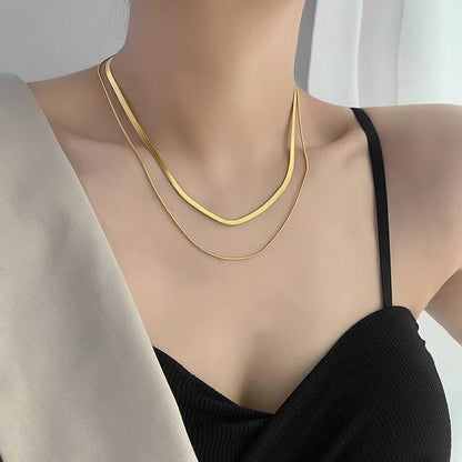 A person wearing a black tank top showcasing a double snake chain necklace with 18k gold plating. Lilyah Jewelry Gold Plated Necklace. Gift Ideas for her.