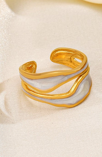 An 18k gold plated midnight pop open ring with a white inlay, displayed on a yellow fabric background. Lilyah Jewelry Gold Plated Ring . Stunning, minimalistic, adjustable, elegant and statement ring. Gift idea for her.