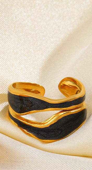 An 18k gold plated midnight pop open ring with a black inlay, displayed on a yellow fabric background. Lilyah Jewelry Gold Plated Ring . Stunning, minimalistic, adjustable, elegant and statement ring. Gift idea for her.