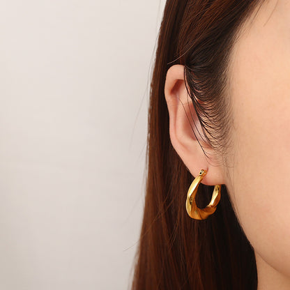 A person wearing 18k gold plated twisted hoop earrings. Lilyah Jewelry Gold Plated Earring. Gift Ideas for her.