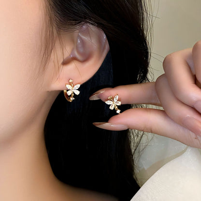 A person wearing 14k gold plated crystal butterfly earrings with a copper inlay and zircon plating. Lilyah Jewelry Gold Plated Earring. Gift Ideas for her.