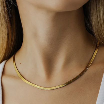 A close-up image of a woman's neck wearing a gold-plated snake chain necklace. Lilyah Jewelry Gold Plated Necklace. Gift Ideas for her.