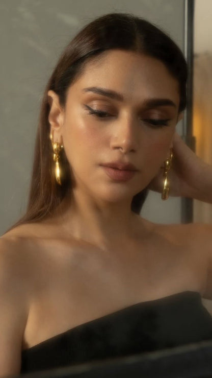 Woman wearing gold earrings with a neutral background. Lilyah Jewelry Gold Plated Earring. Gift Ideas for her.