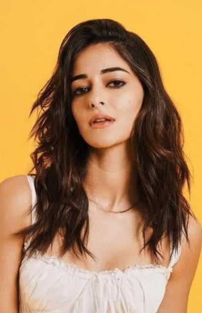 Woman with long dark hair wearing a white top wearing a snake chain against a yellow background. Lilyah Jewelry Gold Plated necklace. Gift Ideas for her.