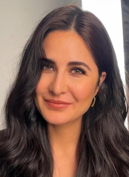 Katrina Kaif with long dark hair smiling against a neutral background wearing Lilyah Jewelry Gold Plated Earring. Gift Ideas for her.